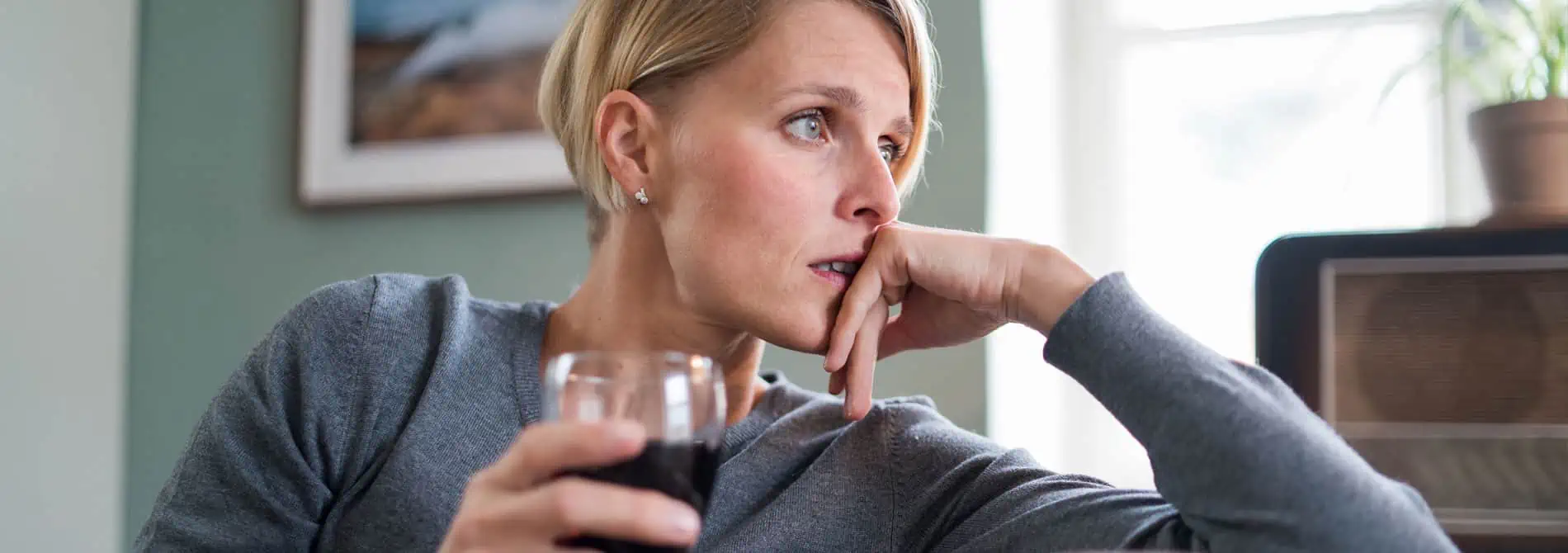 Anxious woman drinking wine